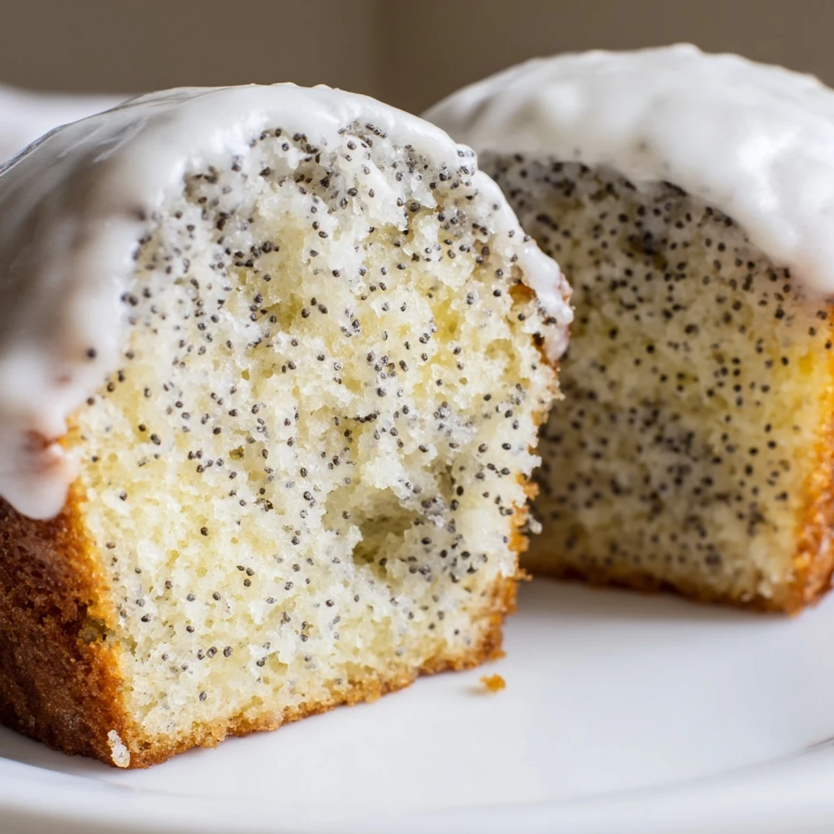 Golden Lemon Poppy Seed Muffins with Lemon Glaze drizzled over the tops, ready to serve with hot tea.