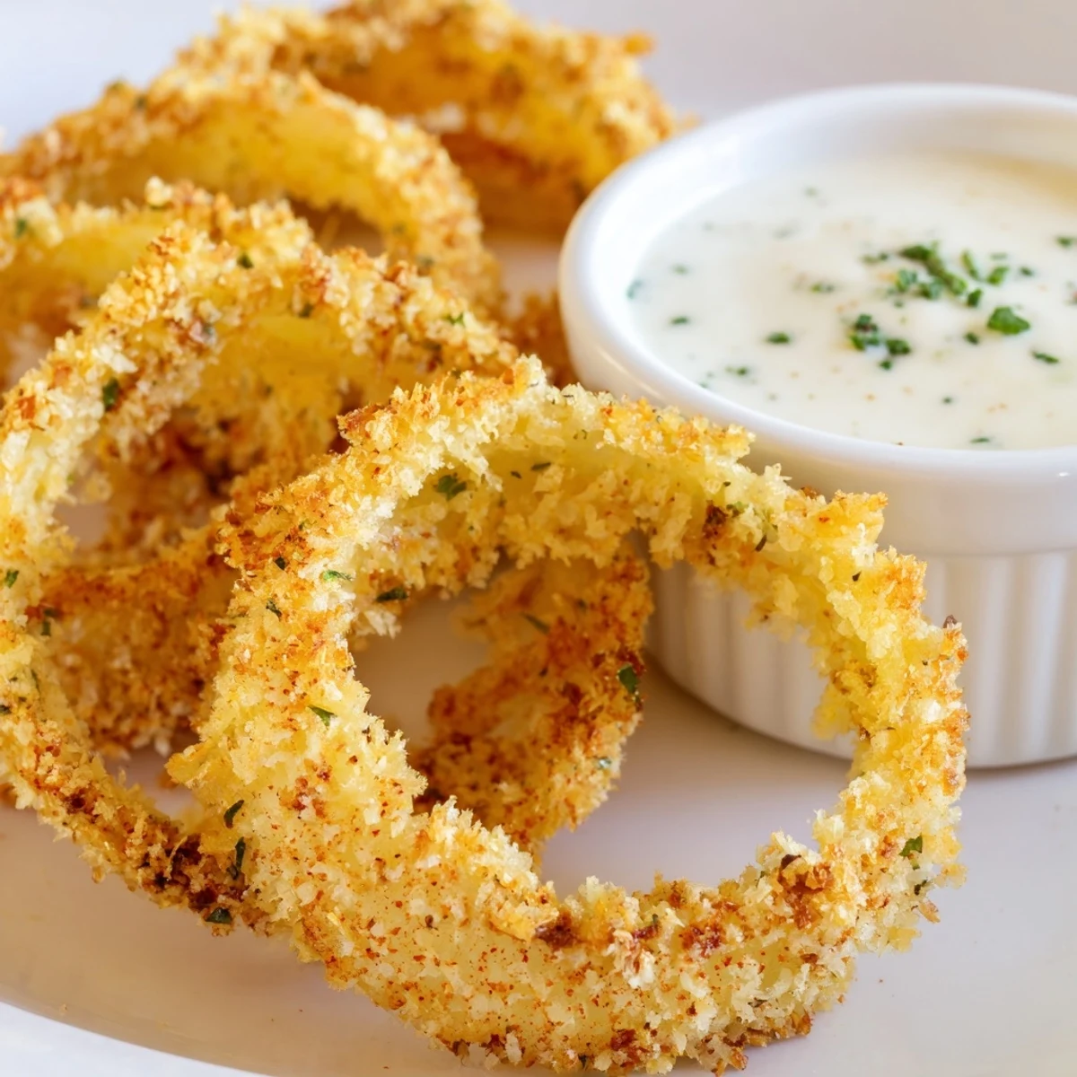 Perfect party appetizer of Crispy Baked Onion Rings with Ranch Dressing, showcasing panko-coated slices ready to be enjoyed by friends.