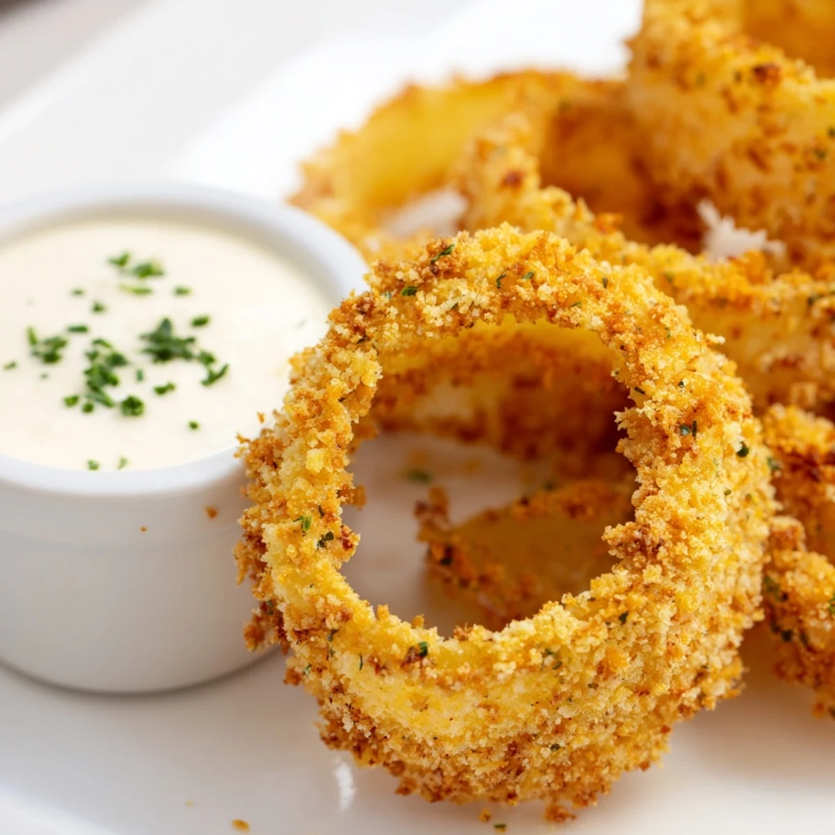 Freshly baked Crispy Baked Onion Rings with Ranch Dressing offer a golden crunch and a cooling, herby dip for an irresistible snack.