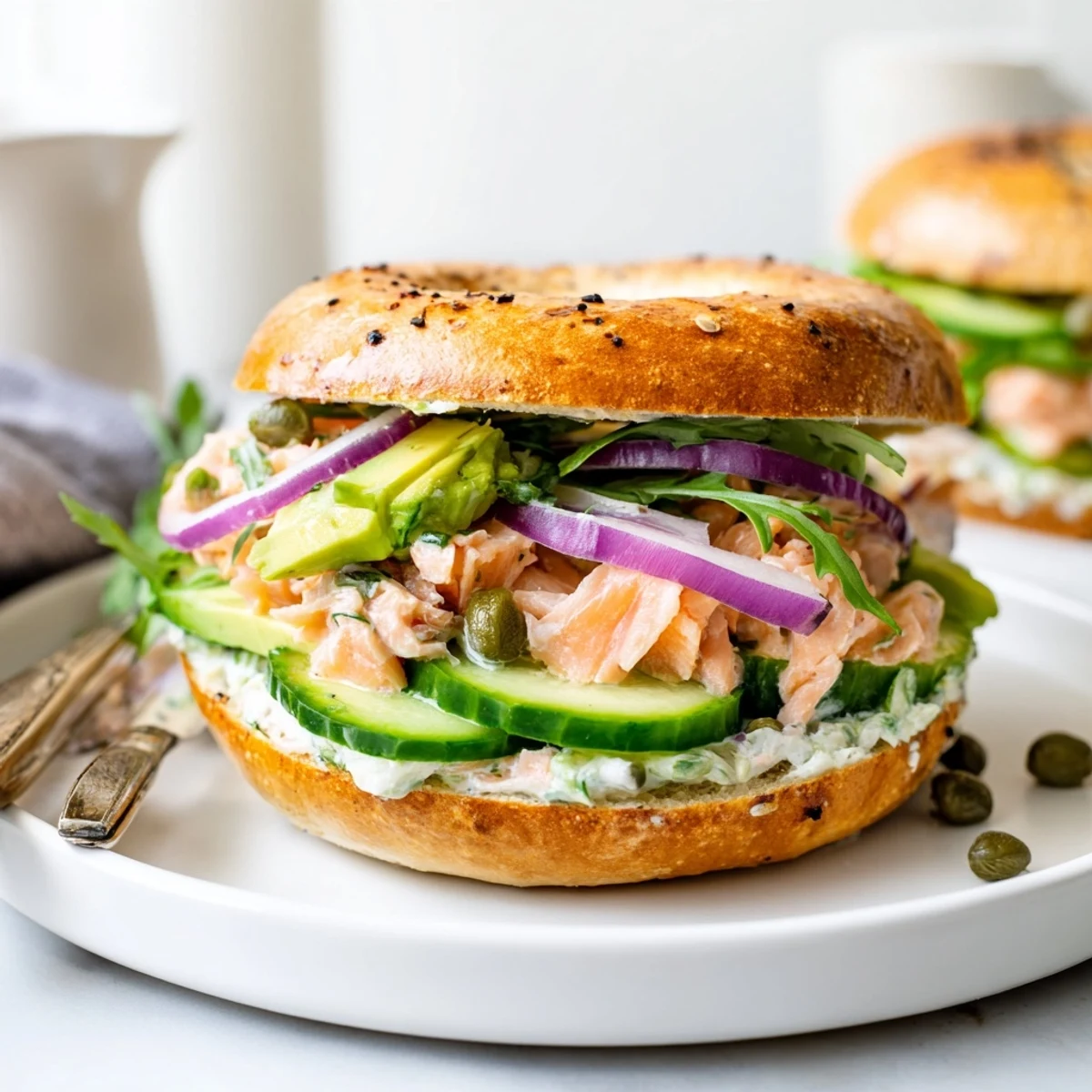Golden toasted bagel halves piled high with flaky baked salmon, herbed cream cheese, crisp cucumber, and avocado slices for a fresh brunch.  