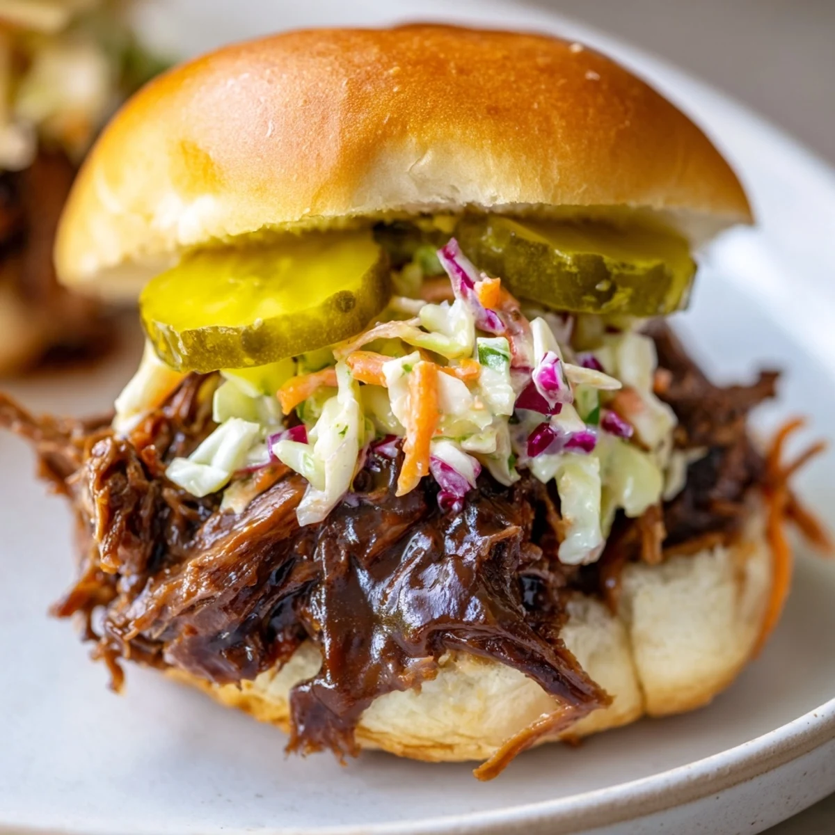 Tender shredded slow cooked beef brisket piled high on a soft slider bun, topped with tangy, creamy coleslaw.
