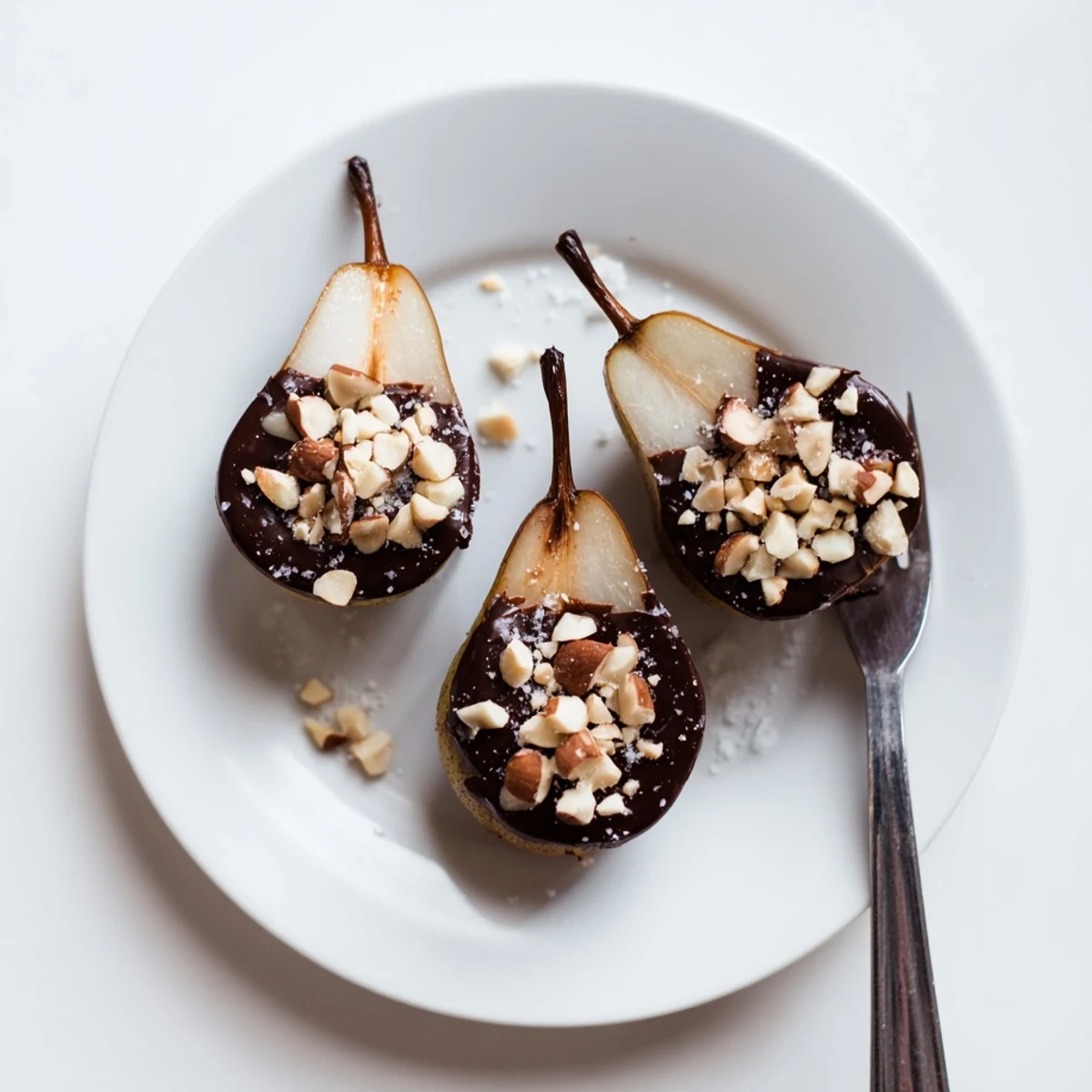 Plate of Chocolate Covered Pears garnished with pistachios and sea salt, perfect for an elegant dessert or holiday party.