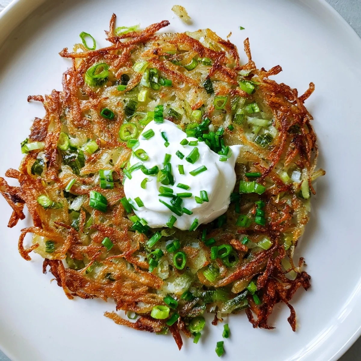 Homemade Potato Cakes with Scallions and Sour Cream, golden brown and ready to enjoy warm.