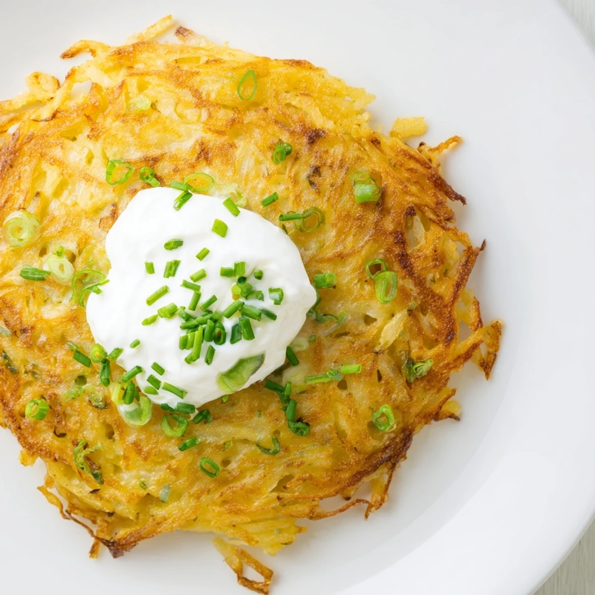 Freshly fried potato cakes flecked with green scallions, paired with tangy sour cream for dipping.  