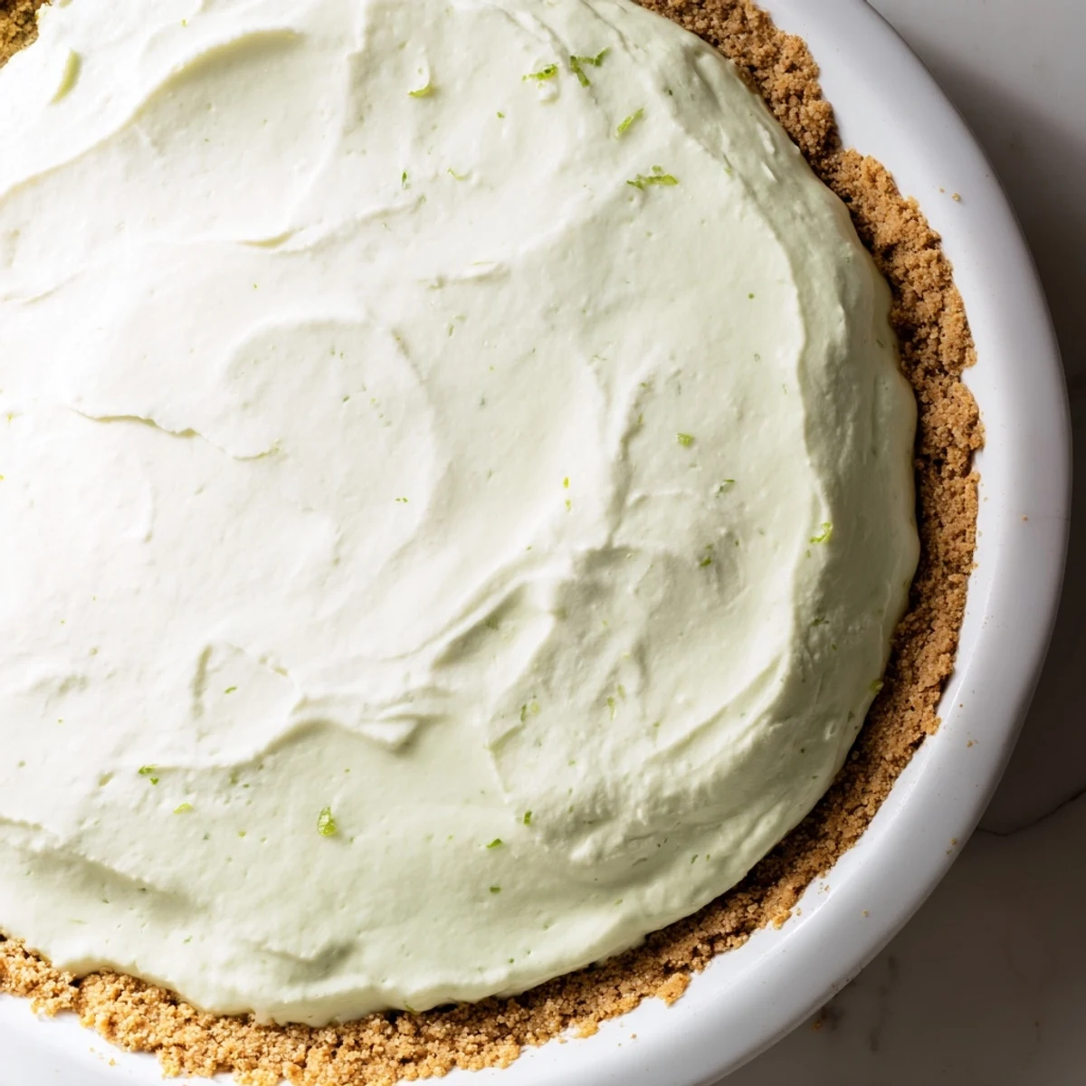 A close-up slice of Key Lime Pie with Whipped Cream Topping shows the bright green filling and fluffy, sweet cream topping.