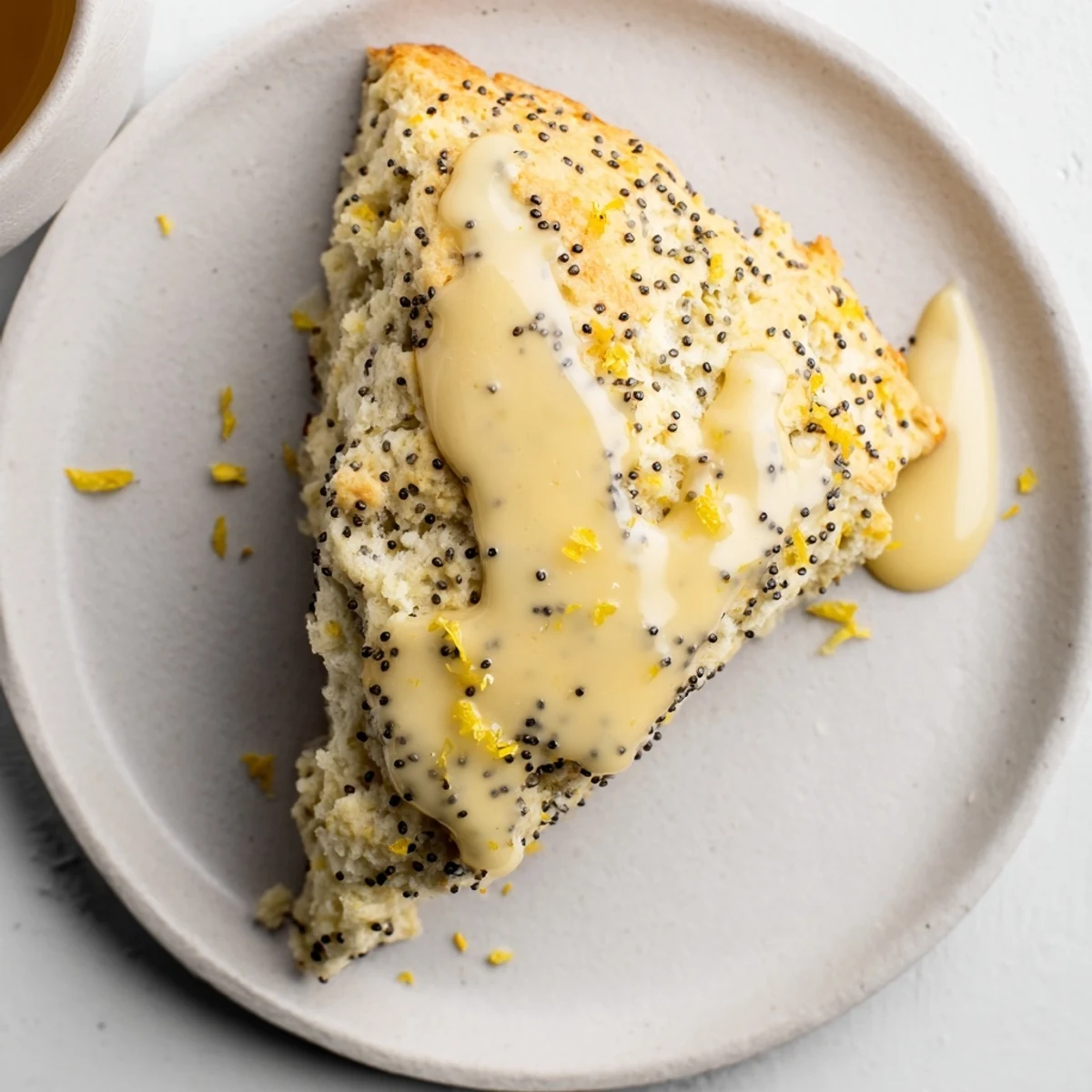 Freshly baked Lemon Poppy Seed Scones on a wooden board, their golden edges glistening with a sweet lemon glaze.