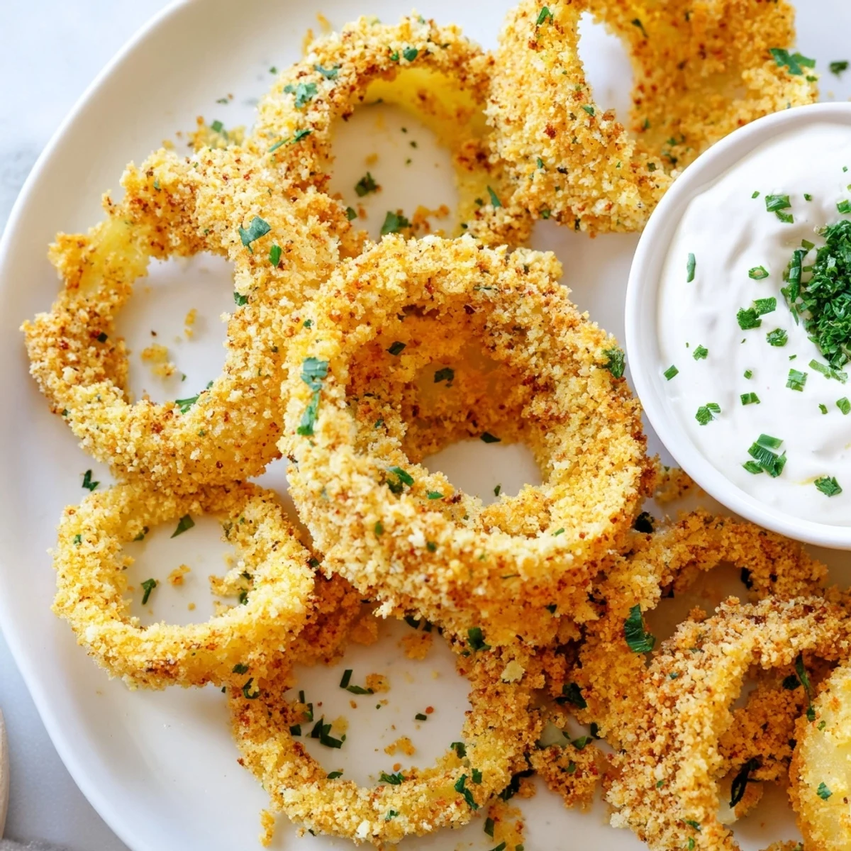 Homemade Crispy Baked Onion Rings with Ranch served hot, highlighting crunchy texture and a side of zesty dipping sauce.