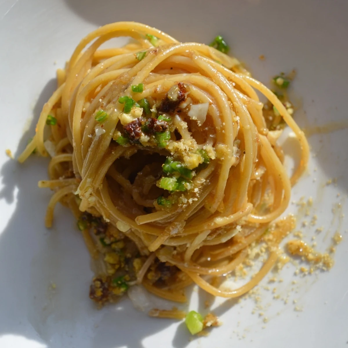 Garlic Noodles tossed in a glossy, rich sauce, served warm in a bowl with optional Parmesan and a side of white wine.