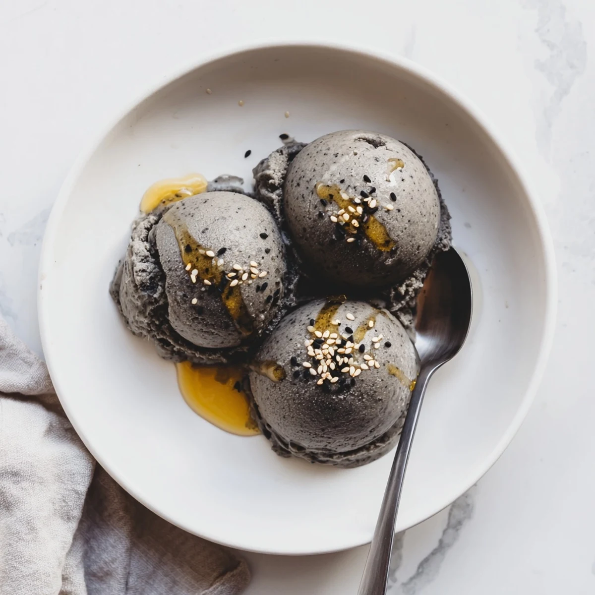 Thick, creamy Toasted Black Sesame Ice Cream with a toasted seed swirl, served in a vintage ice cream bowl.