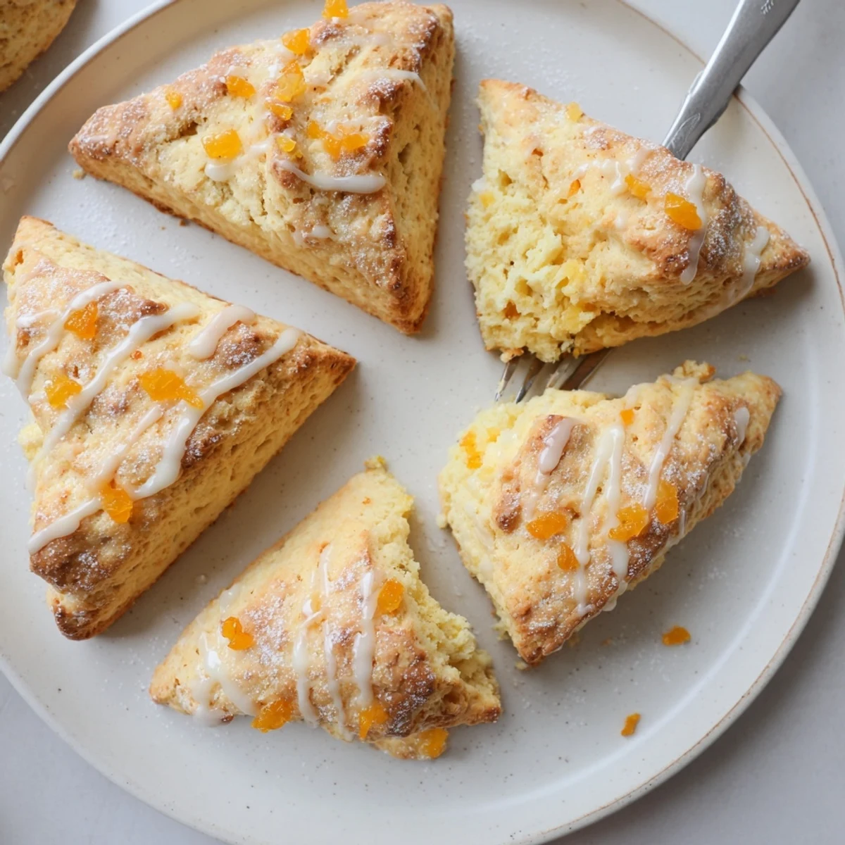 Freshly baked Candied Ginger Orange Scones with visible candied ginger bits and a citrusy aroma.