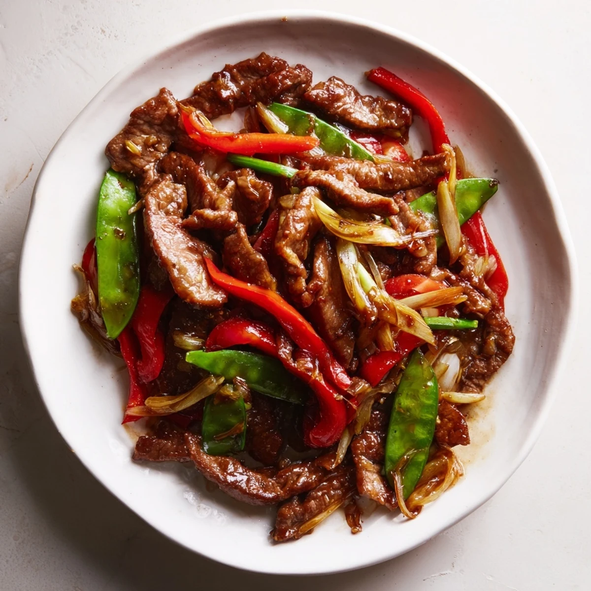 Sizzling wok-ready Beef With Oyster Sauce glazing juicy beef slices alongside colorful onions and fresh ginger for a weeknight dinner.