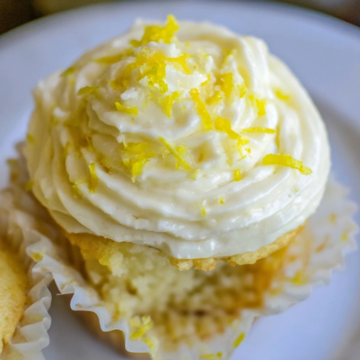 Limoncello cupcakes decorated with zest and a drizzle, ready for spring gatherings with iced tea.
