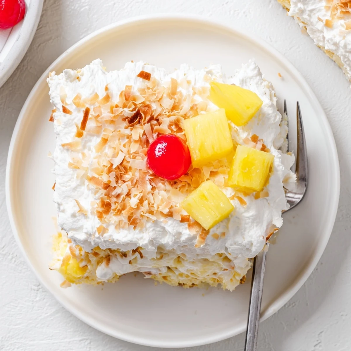 Cool Hawaiian Poke Cake served chilled, topped with shredded coconut and a maraschino cherry for a tropical dessert.