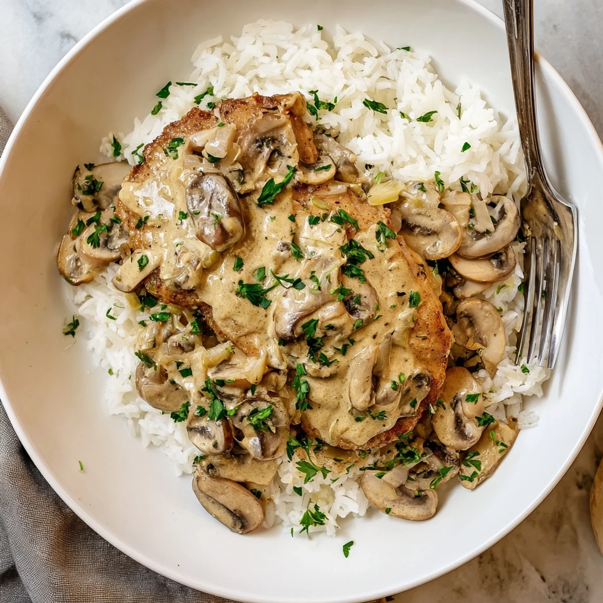 Golden brown chicken breasts nestled in rich parmesan cream sauce over fluffy white rice