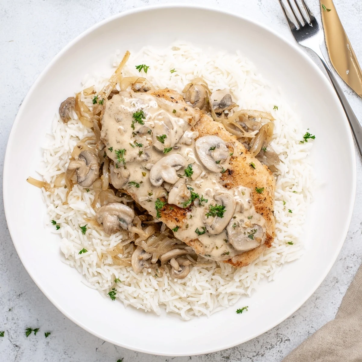 Home-style creamy smothered chicken and rice dish garnished with parsley and ready for dinner