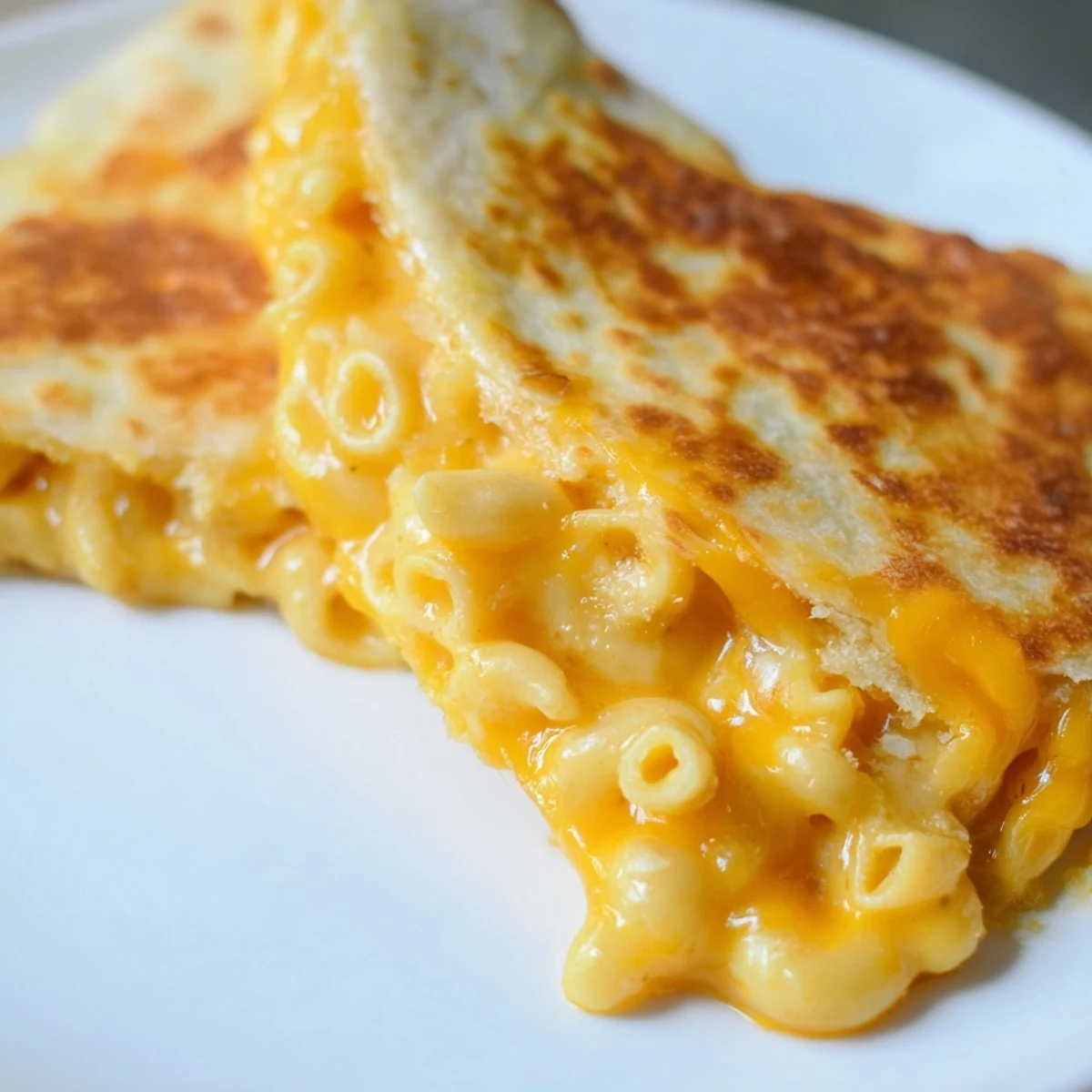 Crispy pan-fried quesadilla stuffed with cheddar mac and cheese on wooden board