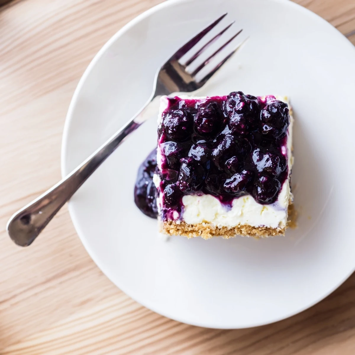Velvety blueberry cheesecake with swirled berry sauce and buttery crust sliced for dessert