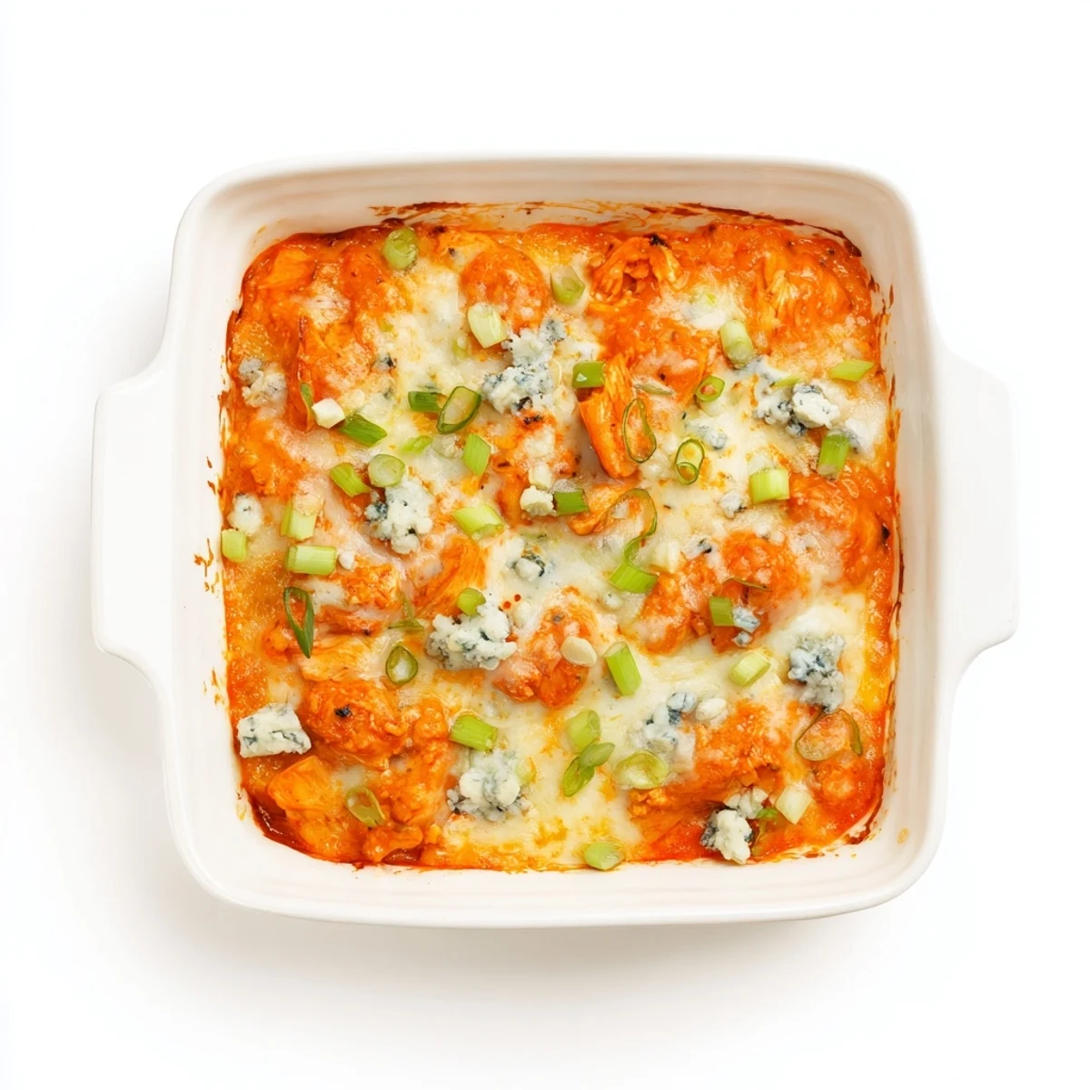 Creamy buffalo chicken cheese bake topped with green onions and blue cheese crumbles on a rustic wooden board