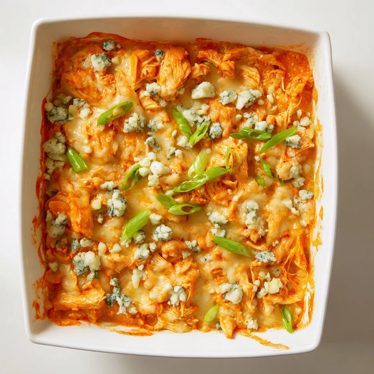 Golden bubbly buffalo chicken cheese bake fresh from the oven with melted cheddar and mozzarella