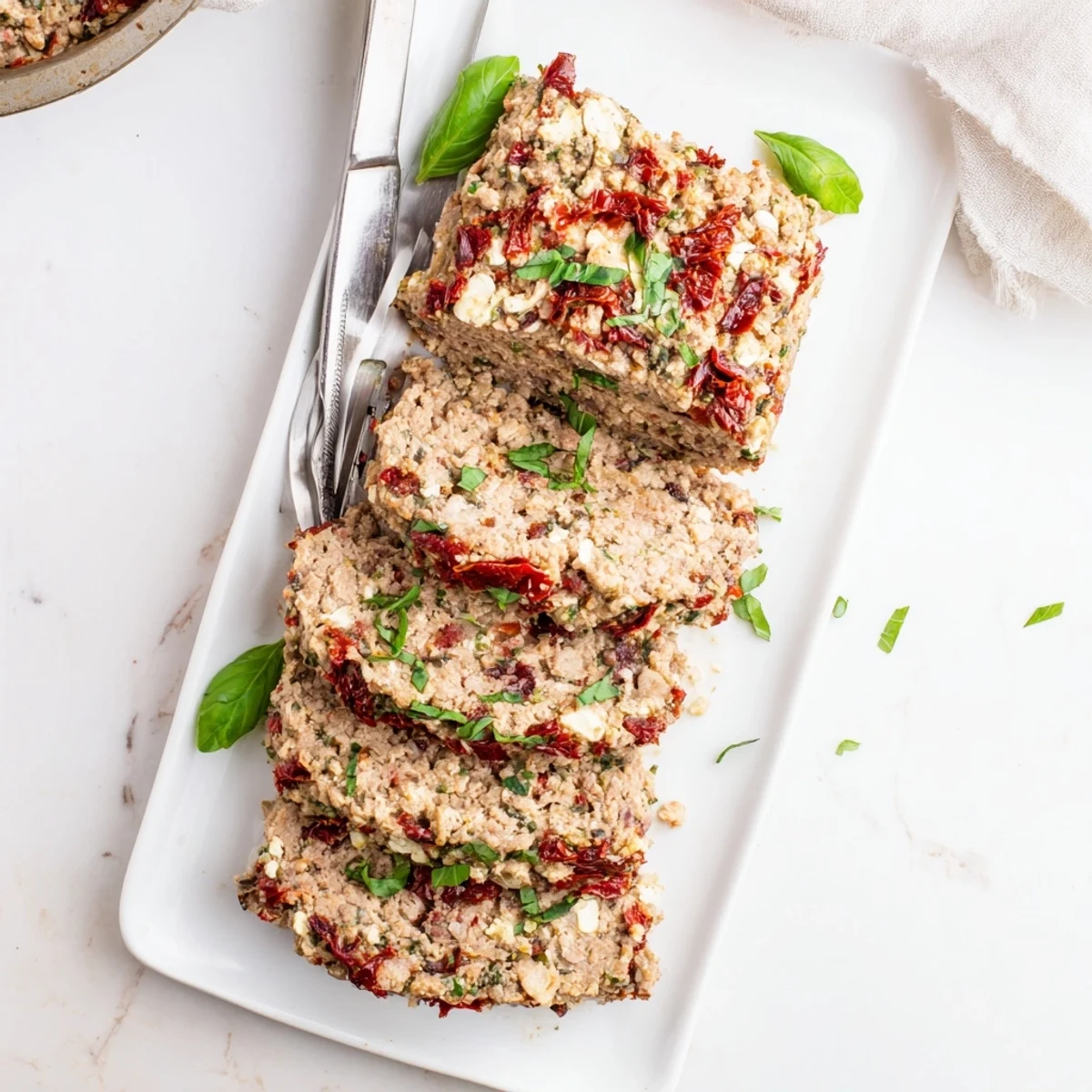 Baked Mediterranean turkey meatloaf with roasted red peppers and herbs ready for slicing