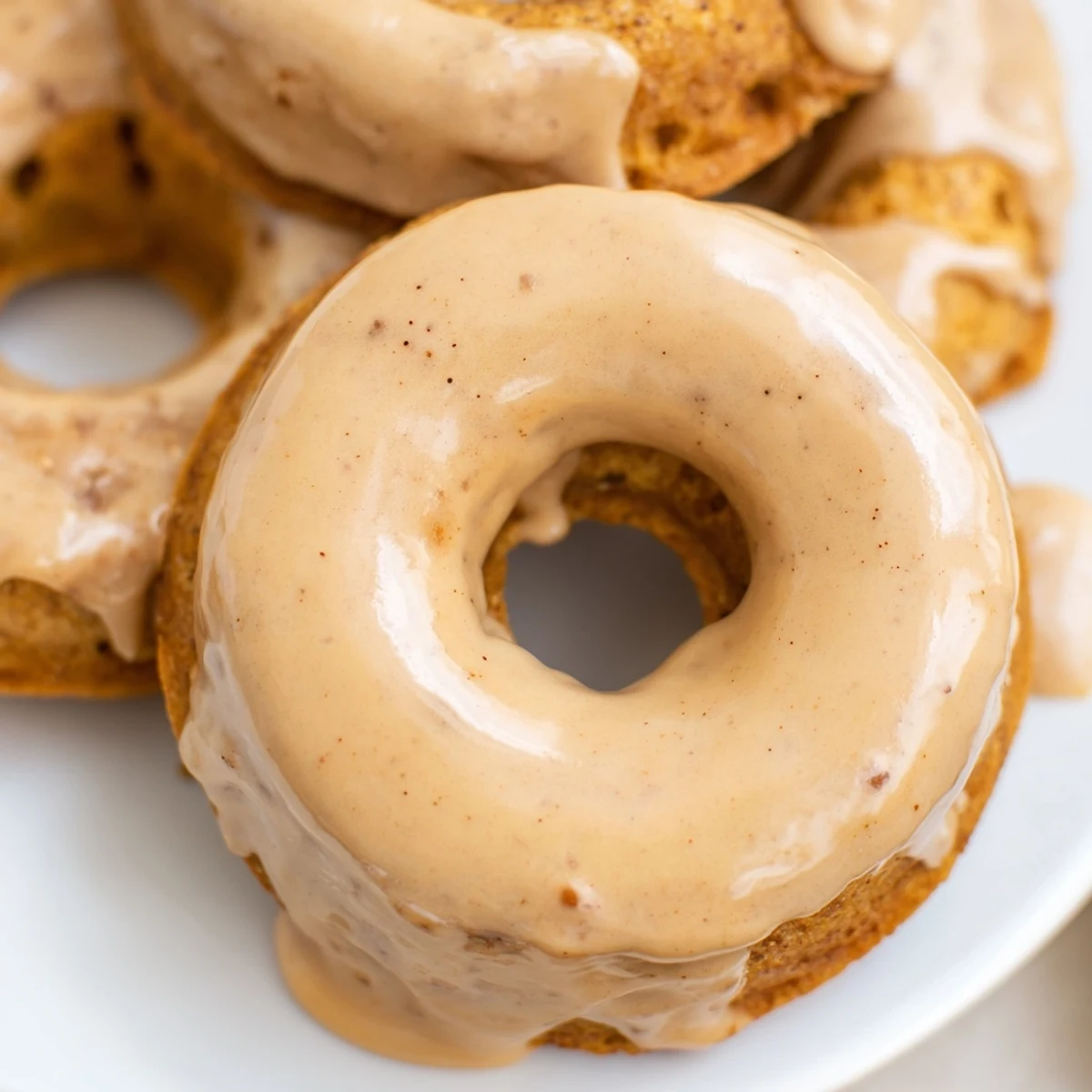 Golden maple pumpkin mochi donuts with sweet glaze drizzling down chewy gluten-free rings