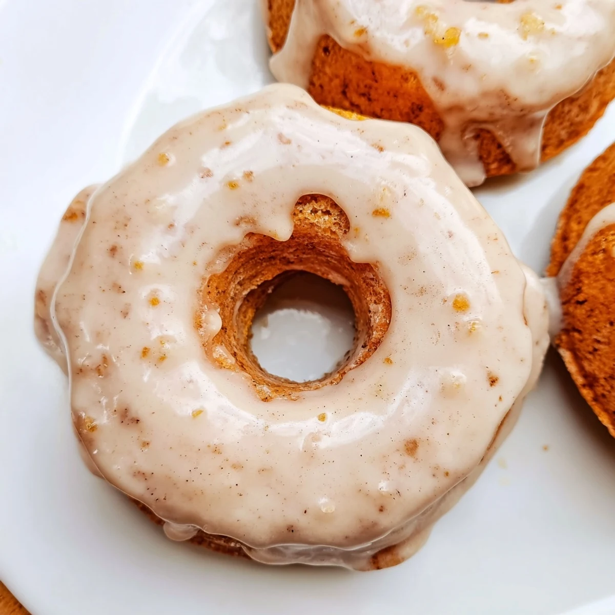 Soft pumpkin mochi donuts glazed with maple syrup arranged on serving plate for fall dessert
