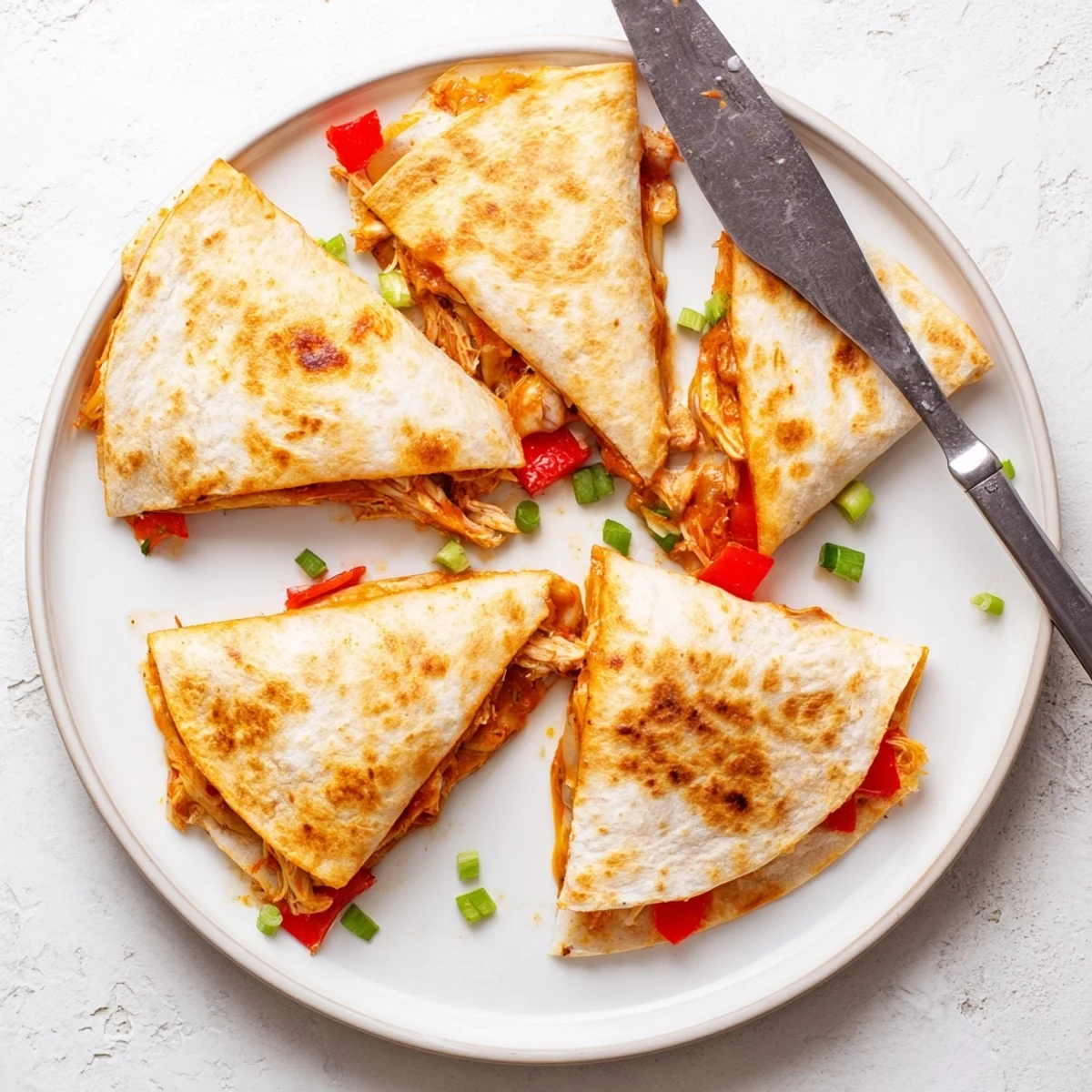 Easy chicken and cheese quesadillas cut into wedges on a serving platter