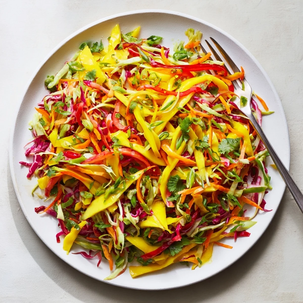 Vibrant mango slaw plated as a refreshing side with crunchy vegetables and bright lime citrus flavors