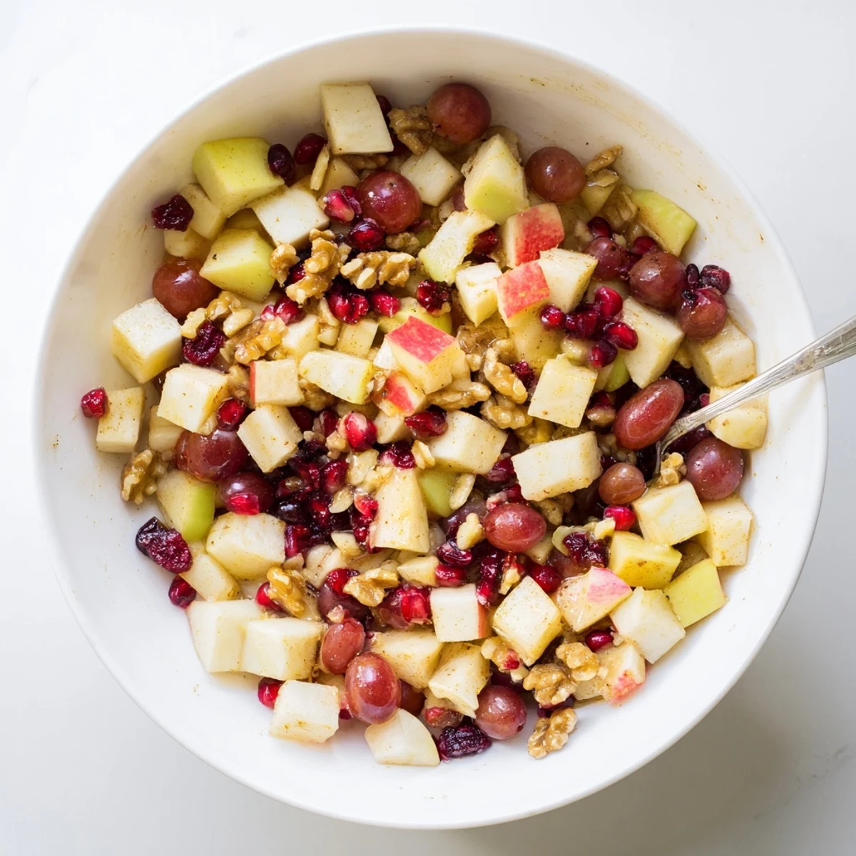 Colorful bowl of fresh Minute Fall Fruit Salad with diced apples, pears, pomegranate arils, and walnuts tossed in citrus honey dressing