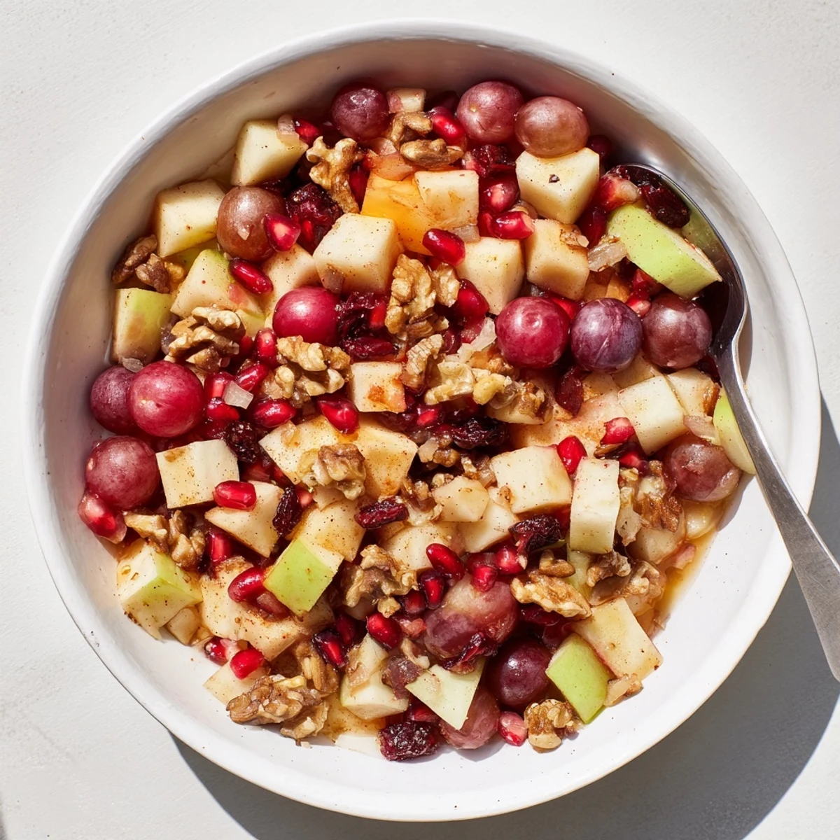 Rustic wooden table displaying vibrant Minute Fall Fruit Salad featuring autumn fruits and crunchy walnuts drizzled with cinnamon honey glaze