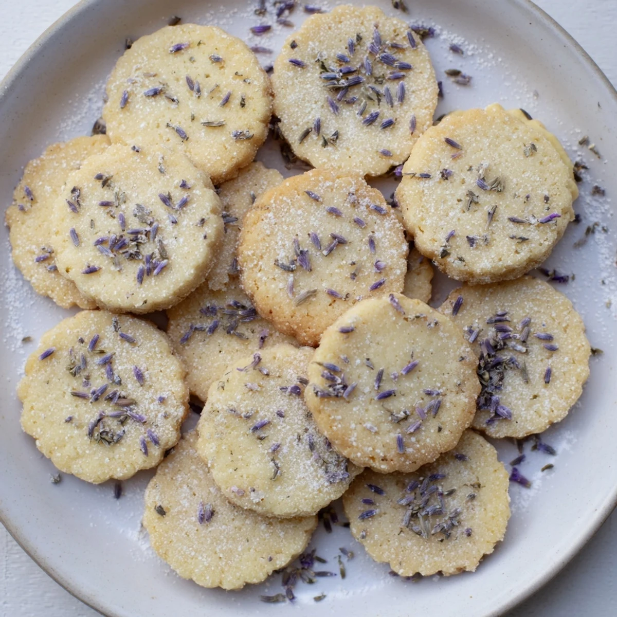 Golden lemon lavender cookies dusted with powdered sugar on a white baking sheet