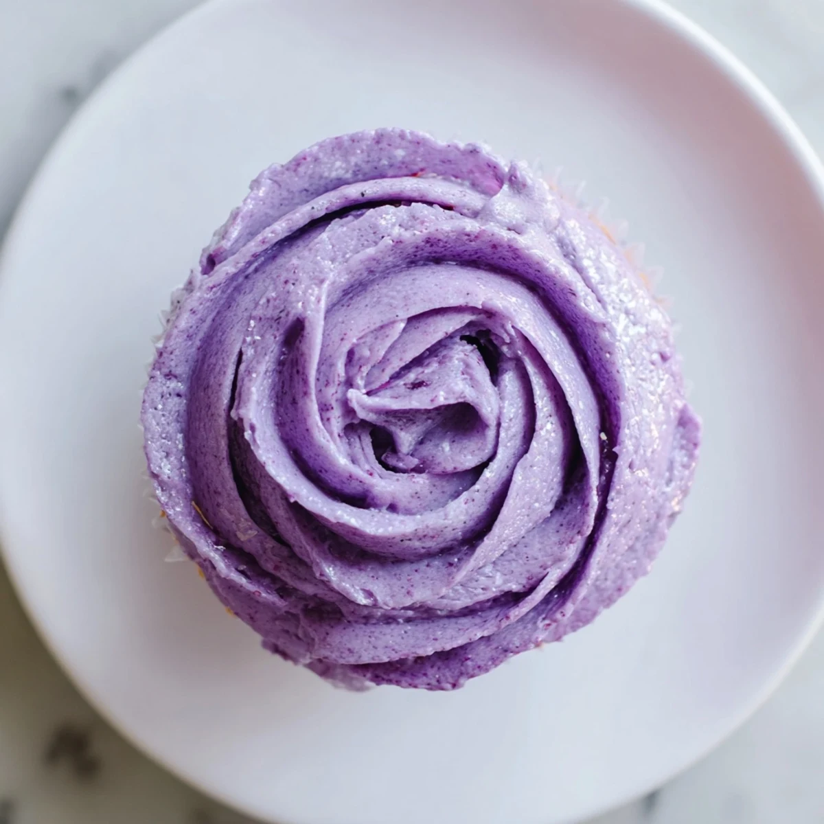 Vibrant grape soda cupcakes with grape buttercream and colorful sprinkles arranged on a serving platter
