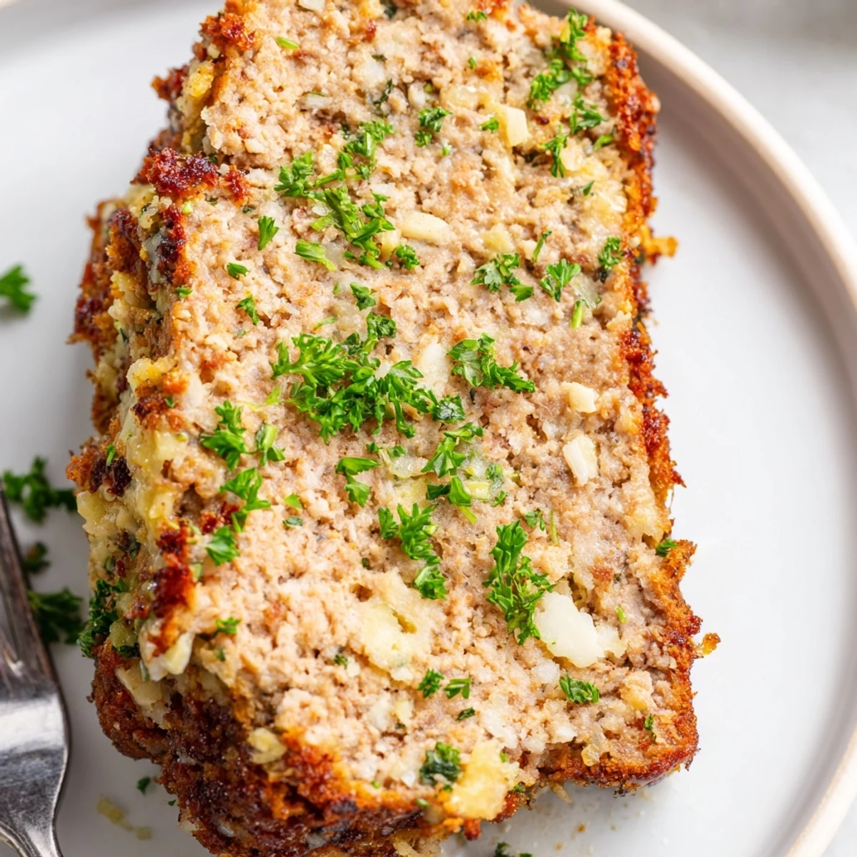 Savory garlic parmesan chicken meatloaf loaf with golden cheesy topping ready to serve