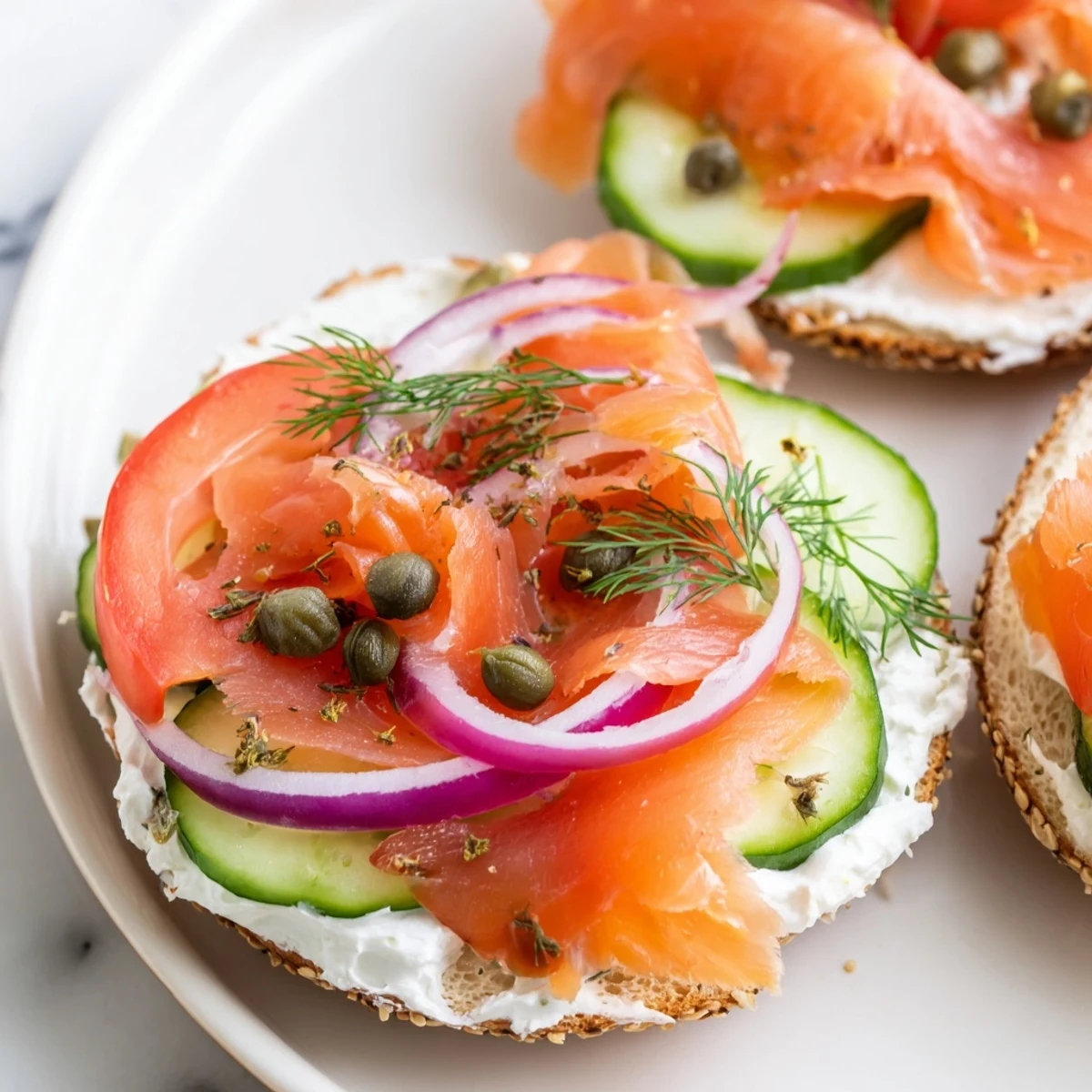 Toasted smoked salmon bagel sandwich layered with cream cheese, fresh vegetables, capers, and dill