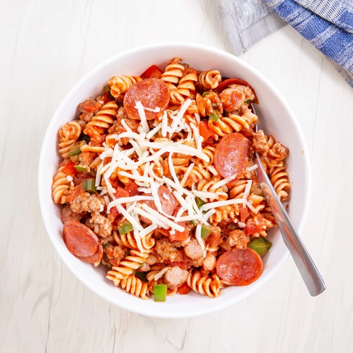 Golden cheesy Crockpot Pizza Pasta with melted mozzarella and pepperoni slices in a slow cooker