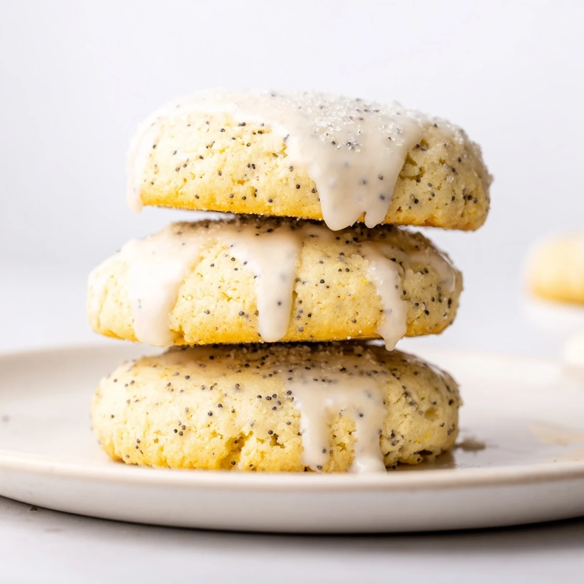 Golden lemon poppy seed cookies with crackly tops drizzled with sweet citrus glaze on a rustic serving plate