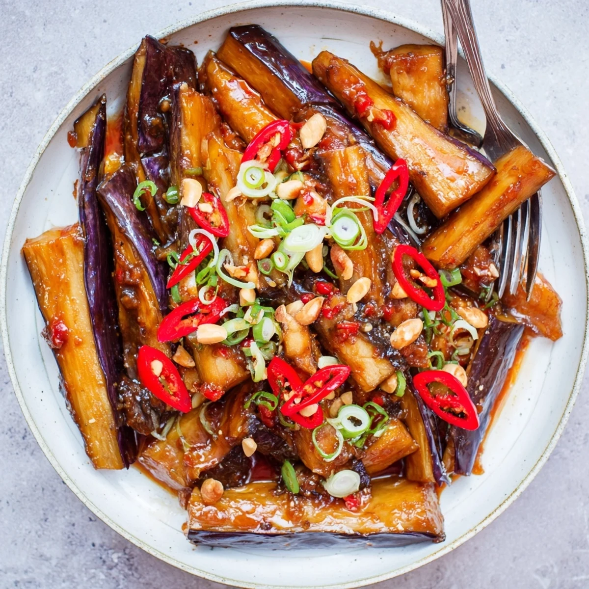 Pan-fried Sichuan Style Braised Aubergines, tender, glossy, finished with sesame oil.