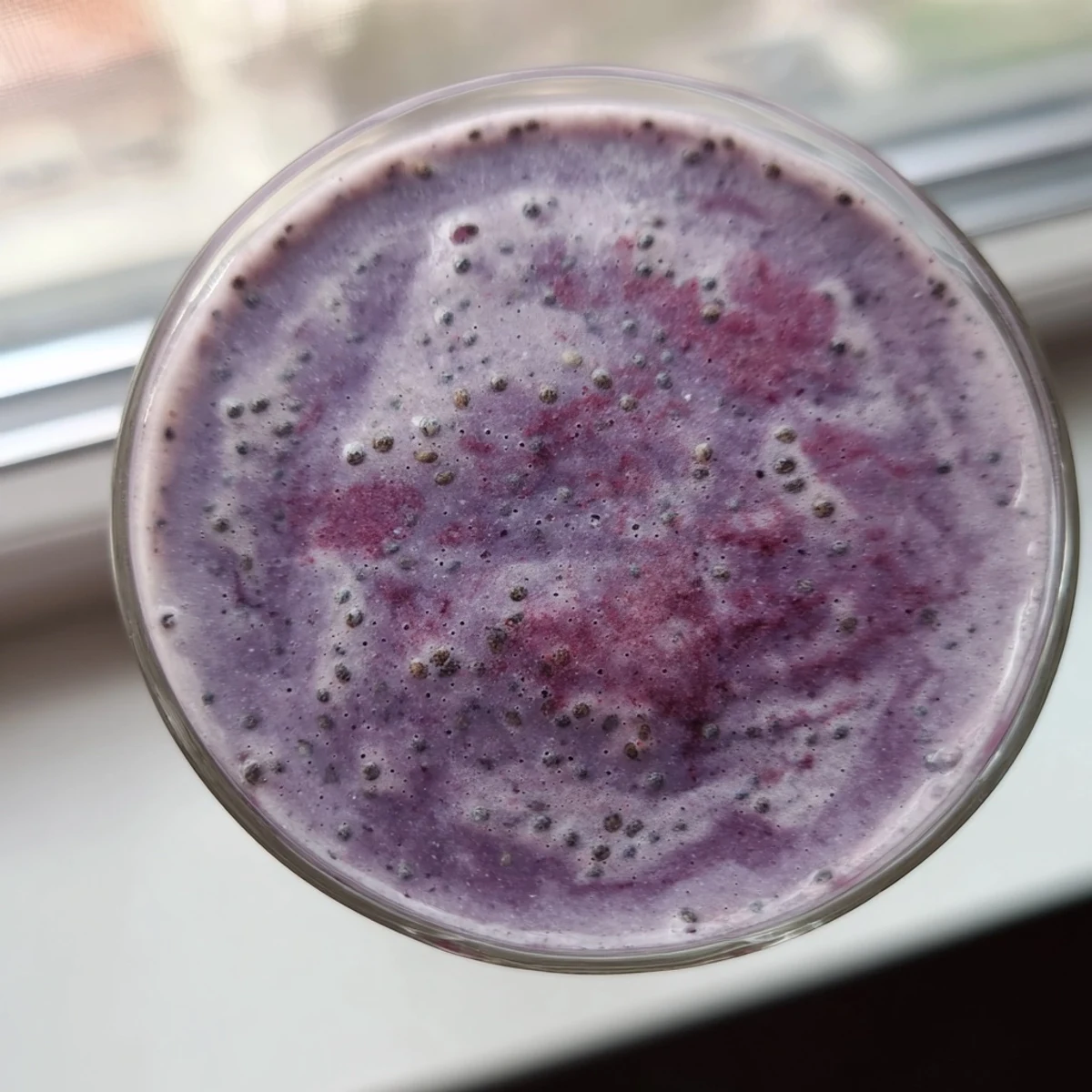 Thick nutrient-rich chia seed smoothie topped with extra seeds and sliced fresh strawberries