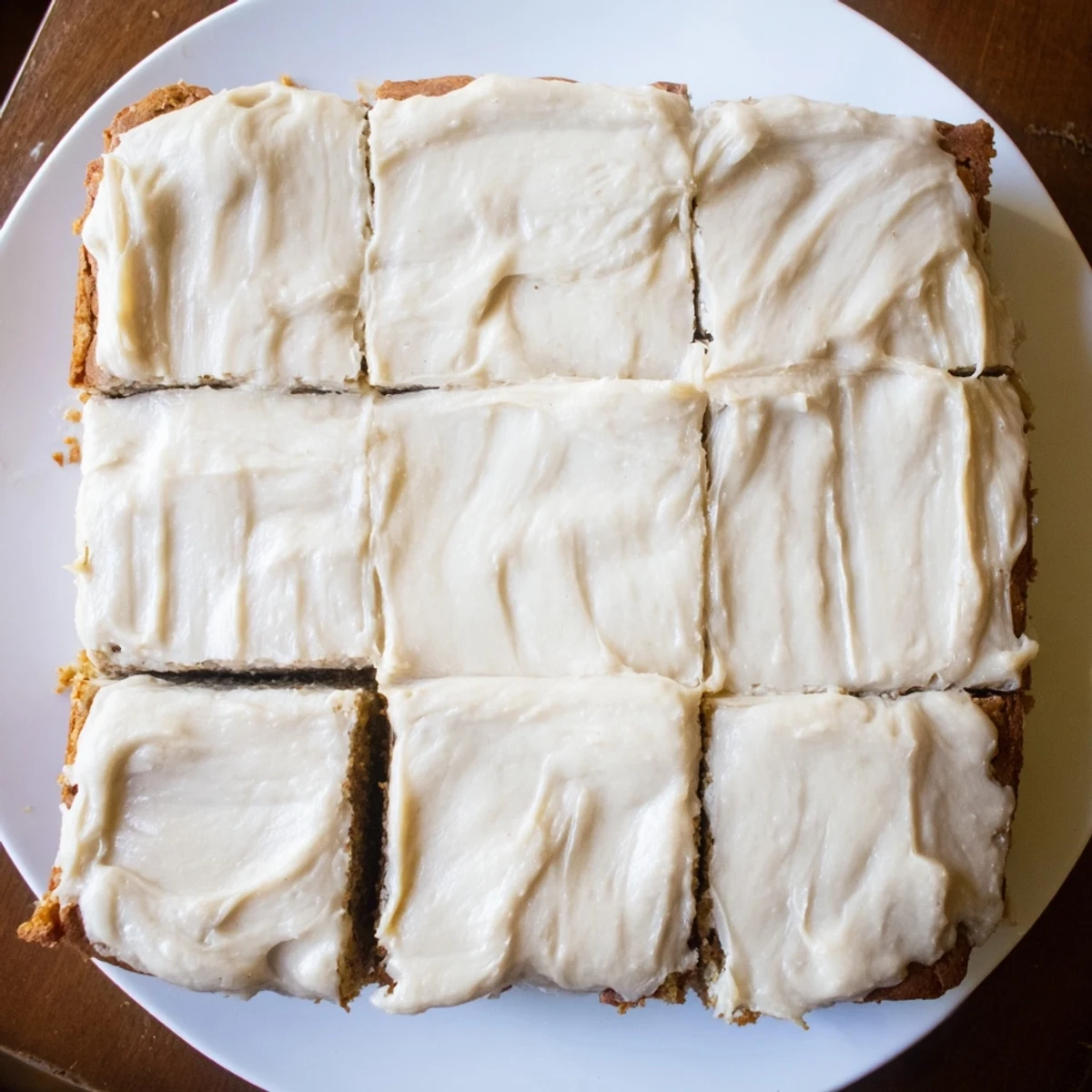 Fudgy banana bread brownies sliced into squares with generous brown butter frosting on a marble surface