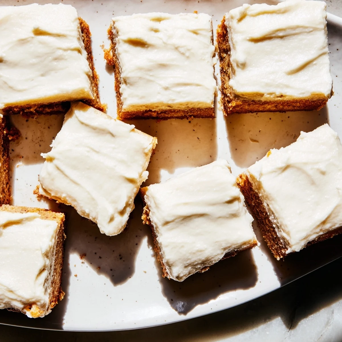 Golden banana bread brownies with caramelized brown butter frosting drizzle and fork resting nearby