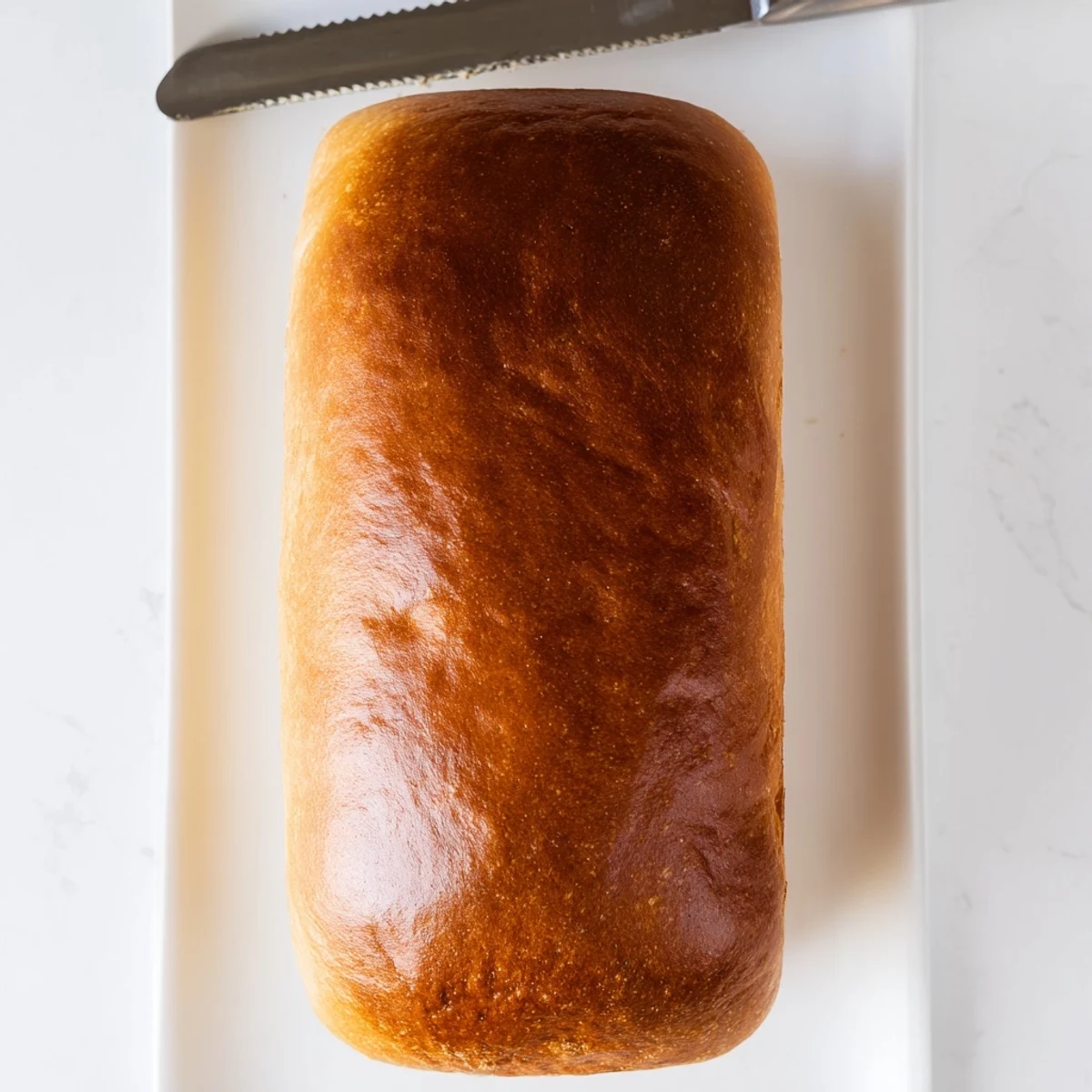 Two freshly baked loaves of homemade Amish white bread with lightly golden crusts