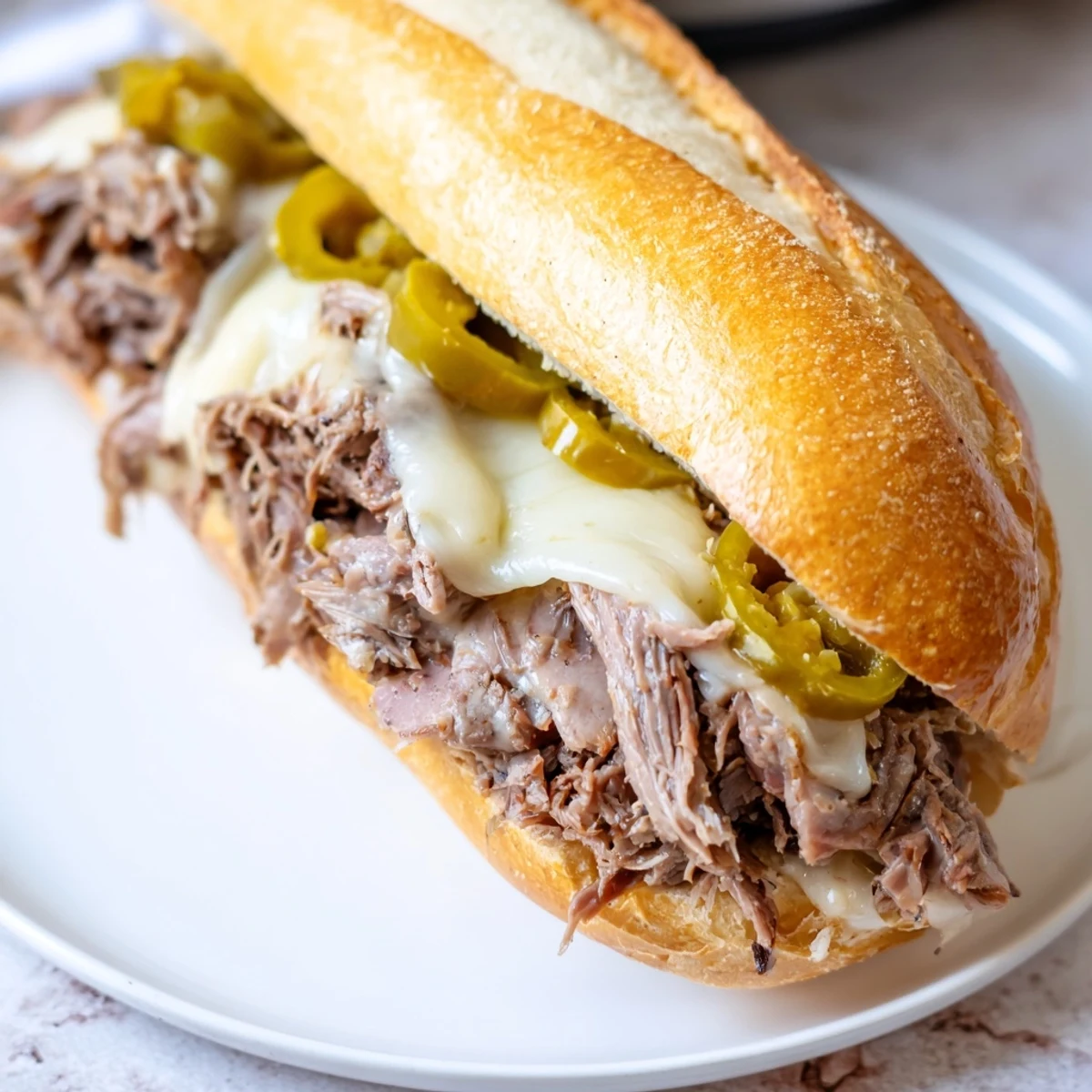 Savory slow cooker Italian roast beef sandwiches piled on crusty rolls with melted provolone