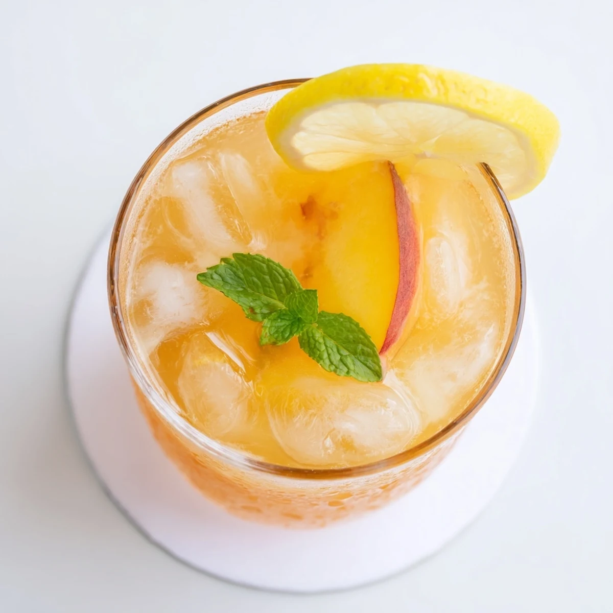 Refreshing fresh peach lemonade drink served chilled with floating peach and lemon garnish