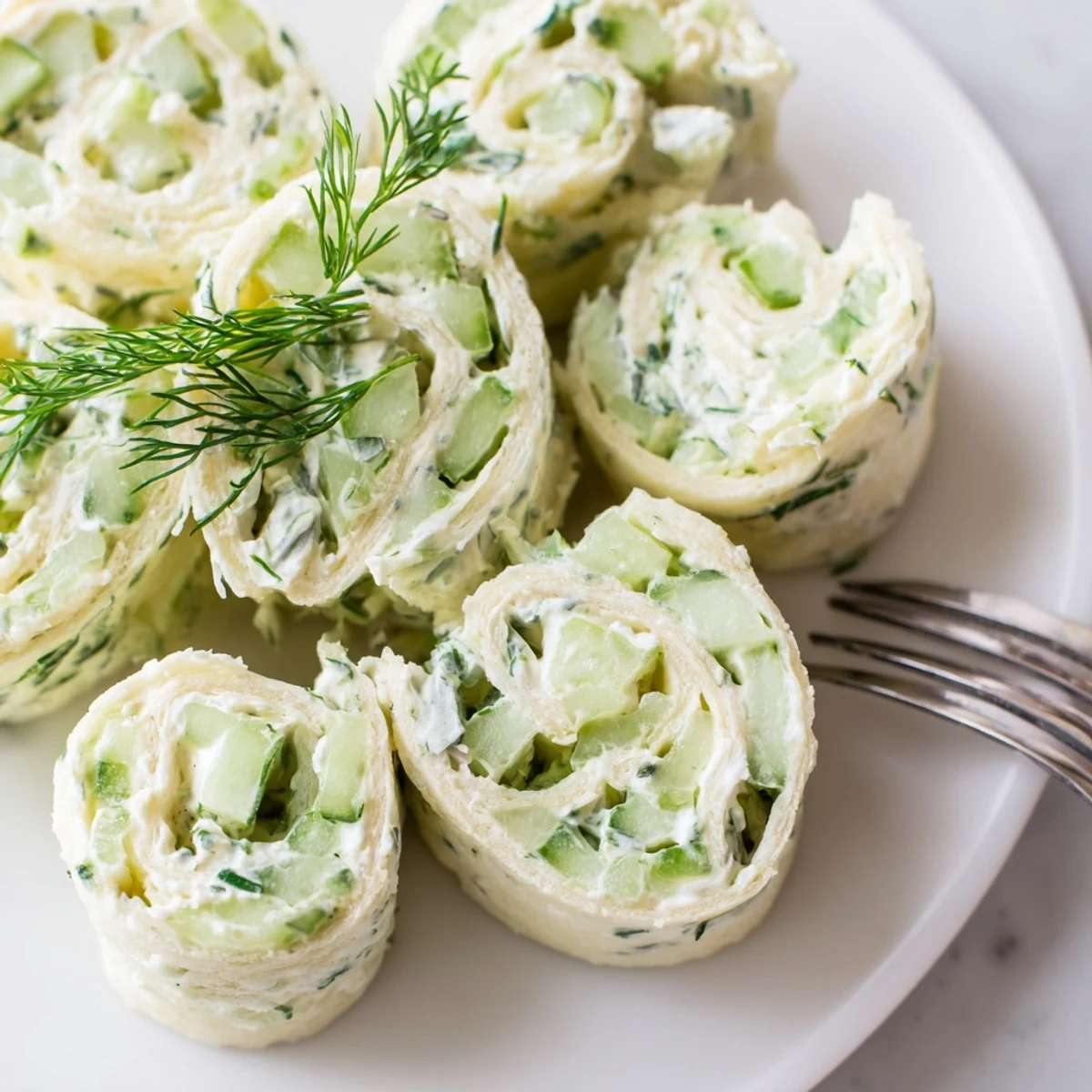 Party-ready Cucumber And Dill Pinwheels sliced into rounds, garnished with dill sprigs