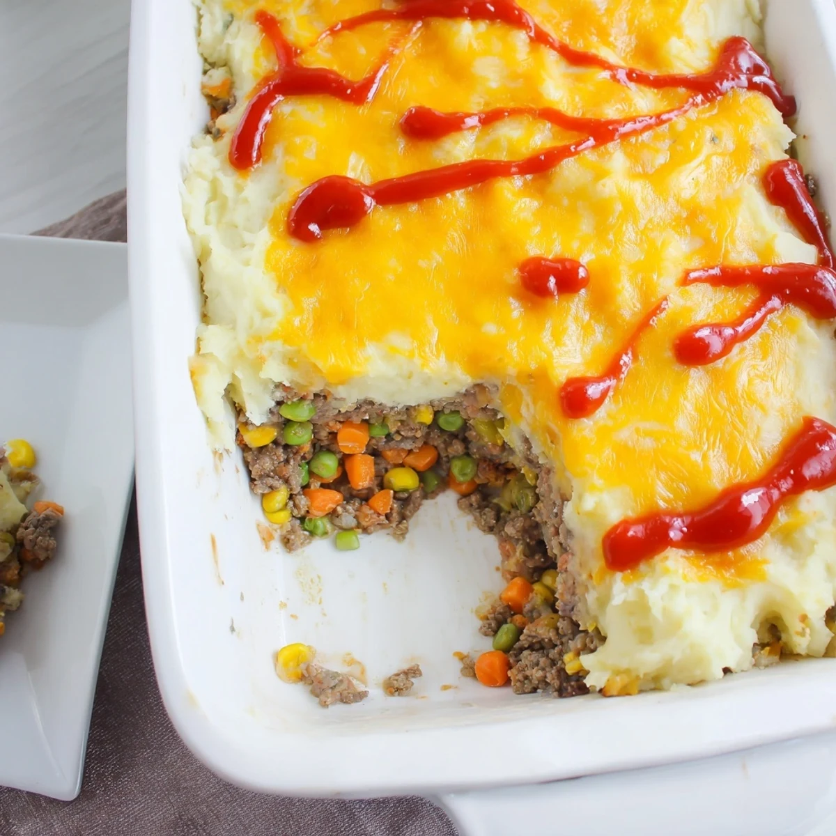 Savory meatloaf casserole serving slice showcasing ground beef pork beneath fluffy mashed potatoes and golden cheese topping