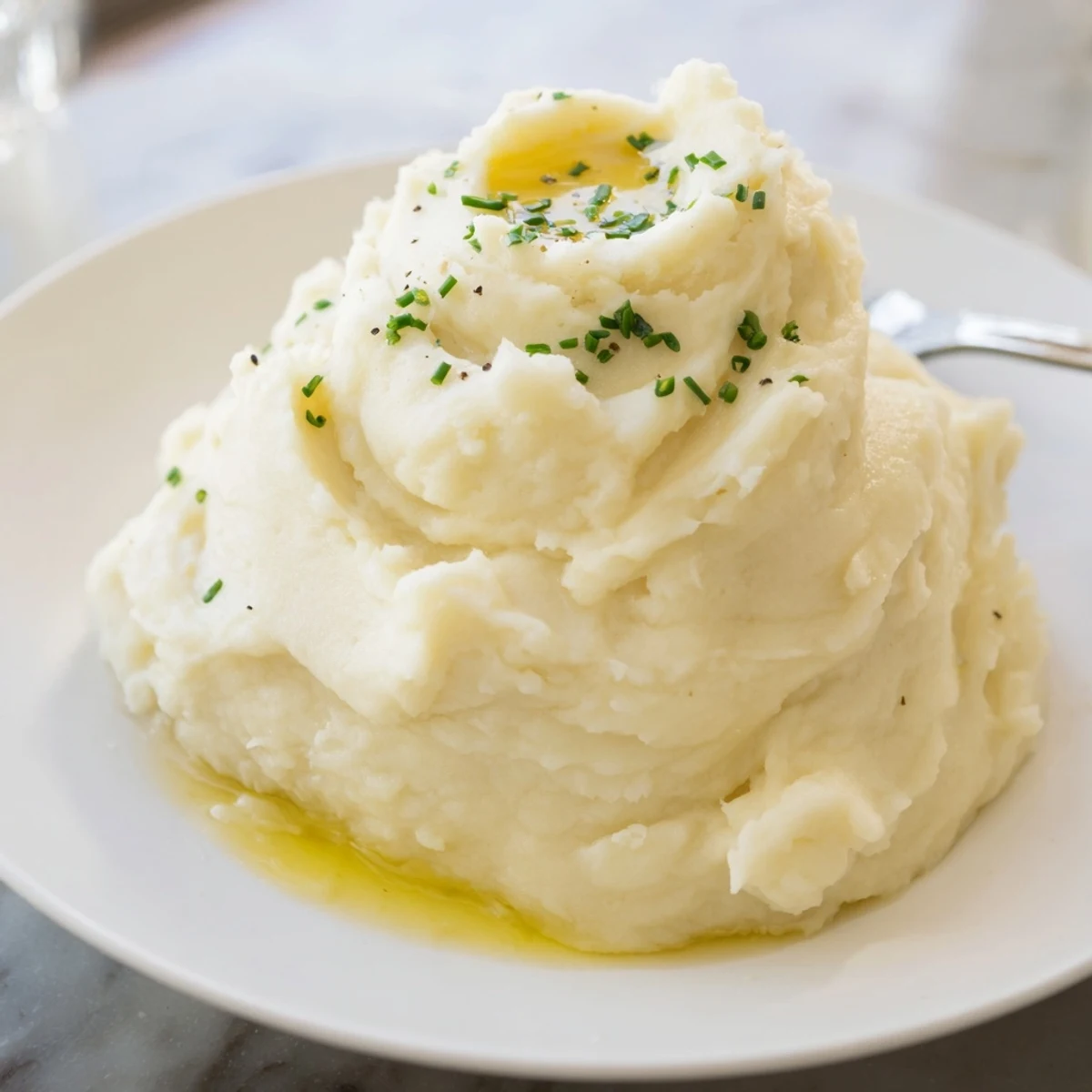 Creamy velvety mashed potatoes piled high in a rustic dish ready to serve