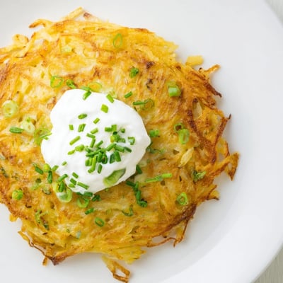 Freshly fried potato cakes flecked with green scallions, paired with tangy sour cream for dipping.  
