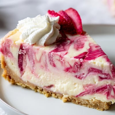 Tangy rhubarb ribbons marble through silky low-carb cheesecake filling atop a spiced buttery almond base